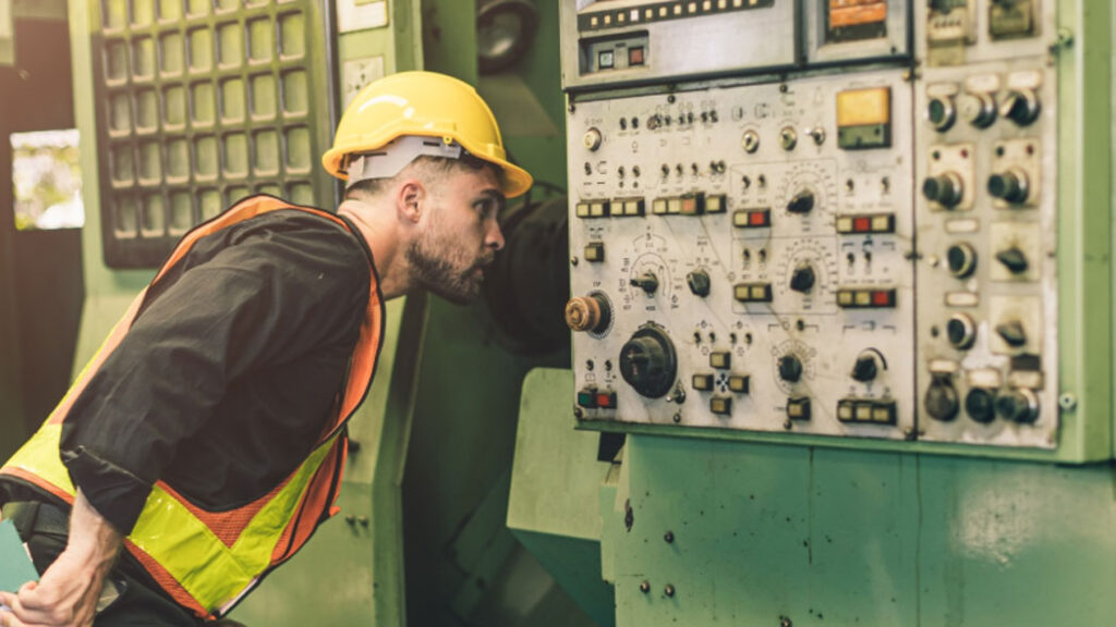 Worker conducting an inspection of machinery to be inputed into FlexManager compliance system