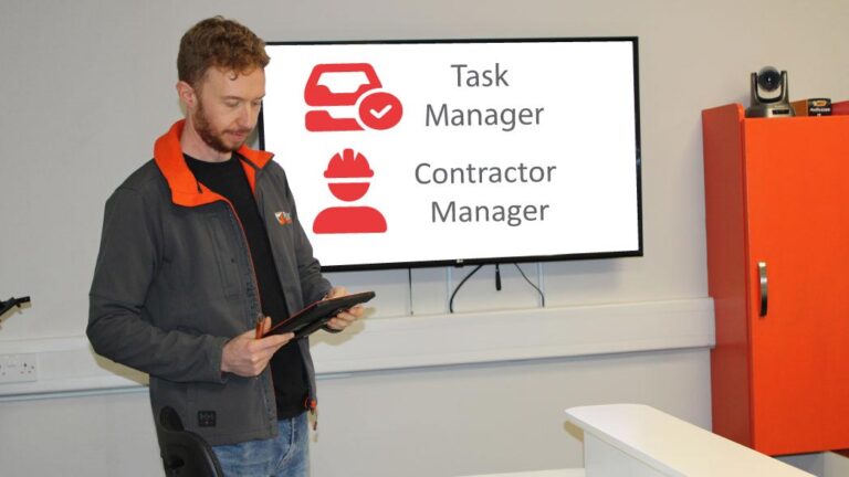 Individual holding a tablet preparing to present on HR and Workforce tools, providing a focus on task manager and contractor manager system software updates.