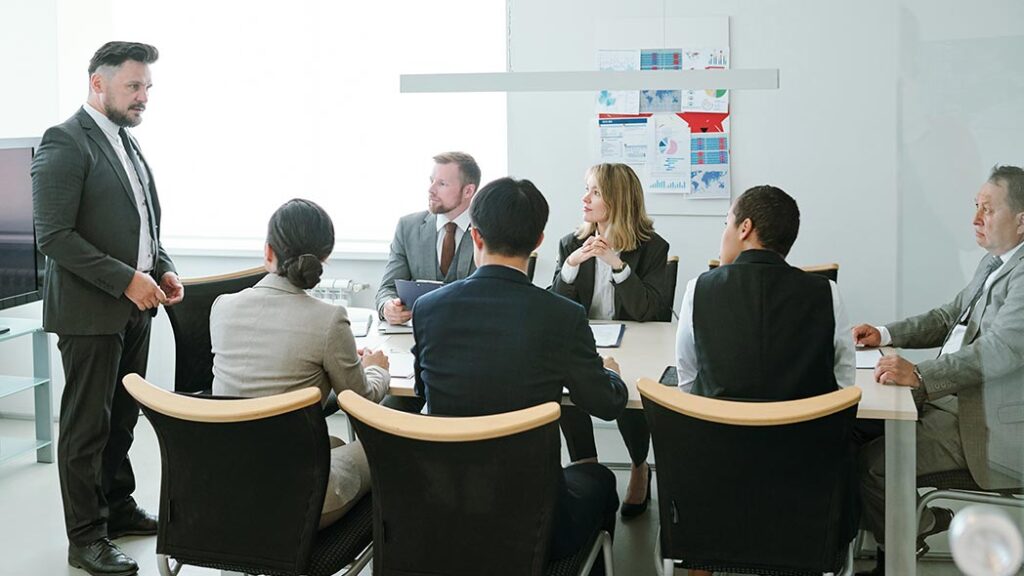 Group of professionals in a board room discussing health and safety standards.