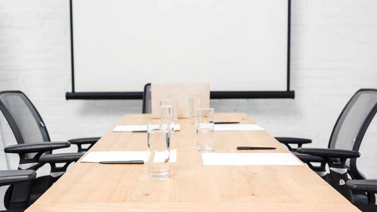 A meeting room with two chairs that will be used to discuss business and operational strategies with FlexManager Meeting Module.