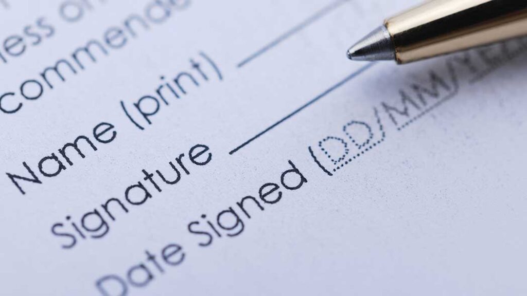 A pen with a piece of paper with a signature line to represent the new legislation that is being brought into law.