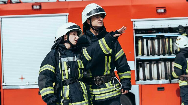 Firefighters discussing strategies during a training exercise to ensure that they are protected when undertaking a fire operation.