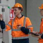 Electrical professionals investigating safety operations of a breaker to ensure compliance.