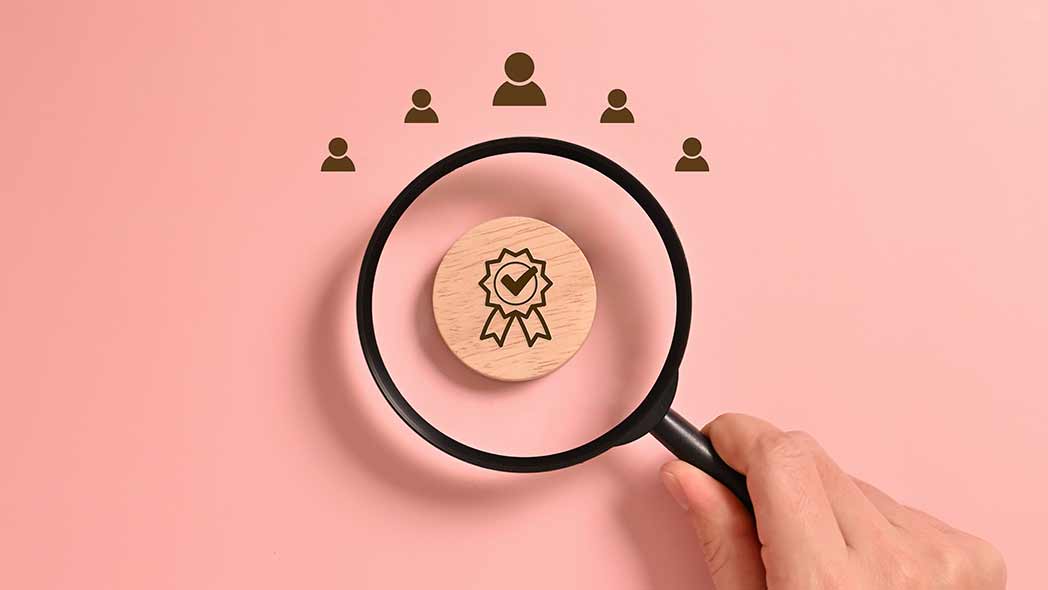 World quality day represented by a magnifying glass hovering over a certification ribbon.