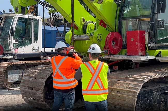 Two workers inspecting heavy machinery equipment.