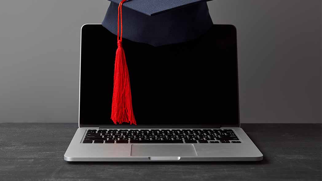 A graduation cap with a computer, symbolizing the progression of employees through FlexManager Training Manager tool.