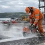 Construction worker cutting concrete on a site in Ireland generating silica dust.