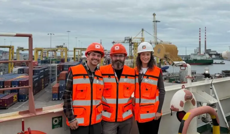 FlexManager team visiting Doyle Shipping Group operations at Dublin Port, with cranes and port machinery operating on the quay.