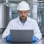 Quality engineer inspecting dairy equipment safety design and compliance documentation