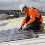 Building contractor inspecting fragile roof sheeting for work at height compliance